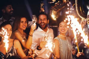 A group of friends celebrates New Year's Eve with champagne and sparklers