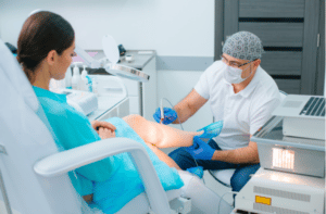 doctor curing veins on the leg of his patient