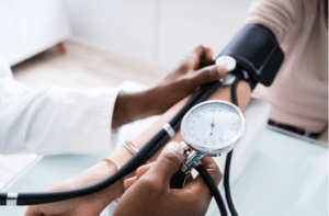 Close up Of Doctor Measuring Patients Blood Pressure With Stethoscope