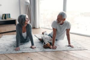 Loving senior couple in sports clothing doing yoga